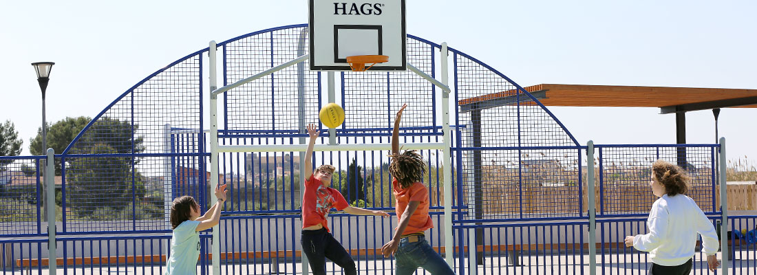 enfants jouant au football sur un terrain multisports personnalisé